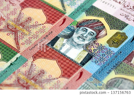 Omani rial paper banknotes pile on table. Oman OMR currency money bills in big amount. Concept of economics, taxation and banking in Oman 137156763