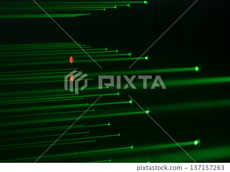 Multiple green laser beams crossing in dark space with red light reflections. Abstract scientific background, optics experiment, high technology concept. Multiple green laser beams crossing in dark space with red light reflections. Abstract scientific background, optics experiment, high technology concept. 137157263