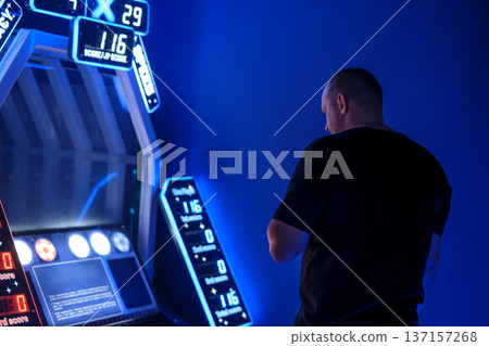 A man plays a soccer game simulator in an entertainment center 137157268