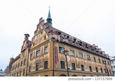 Historic Ulm Rathaus building in Germany features intricate frescoes and a tall spire. The architecture showcases traditional German design elements. Historic Ulm Rathaus building in Germany features intricate frescoes and a tall spire. The architecture showcases traditional German design elements. 137157906