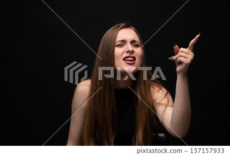 Woman feeling frustration and anger, screaming while pointing finger up, expressing strong negative emotions, stress 137157933