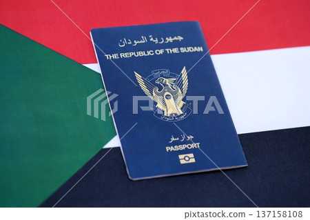 Sudanese passport on flag close up. Official identification document book for citizens of Sudan. Concept of travel and tourism 137158108
