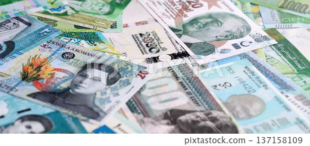 Various currencies money bills banknotes in green color. Many cash bills from different countries in big pile close up. World economy and currency exchange concept Various currencies money bills banknotes in green color. Many cash bills from different countries in big pile close up. World economy and currency exchange concept 137158109