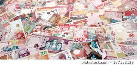 Various currencies money bills banknotes in red color. Many cash bills from different countries in big pile close up. World economy and currency exchange concept Various currencies money bills banknotes in red color. Many cash bills from different countries in big pile close up. World economy and currency exchange concept 137158122