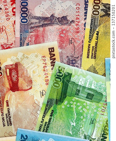 Ugandan shilling paper banknotes pile on table. Uganda UGX currency money bills in big amount. Concept of economics, taxation and banking in Uganda Ugandan shilling paper banknotes pile on table. Uganda UGX currency money bills in big amount. Concept of economics, taxation and banking in Uganda 137158201