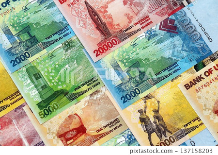 Ugandan shilling paper banknotes pile on table. Uganda UGX currency money bills in big amount. Concept of economics, taxation and banking in Uganda 137158203