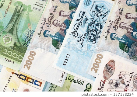 Algerian dinar paper banknotes pile on table. Algeria DZD currency money bills in big amount. Concept of economics, taxation and banking in Algeria Algerian dinar paper banknotes pile on table. Algeria DZD currency money bills in big amount. Concept of economics, taxation and banking in Algeria 137158224