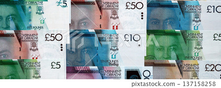 Gibraltar pound paper banknotes pile on table. Gibraltar GIP currency money bills in big amount. Concept of economics, taxation and banking in Gibraltar 137158258