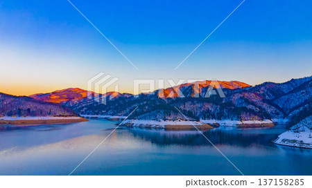 Ono City, Fukui Prefecture. Lake Kuzuryu in winter was so beautiful. The contrast of blue and orange was like a painting. Drone aerial shot. 137158285