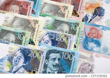 Peruvian sol paper banknotes pile on table. Peru PEN currency money bills in big amount. Concept of economics, taxation and banking in Peru Peruvian sol paper banknotes pile on table. Peru PEN currency money bills in big amount. Concept of economics, taxation and banking in Peru 137158302