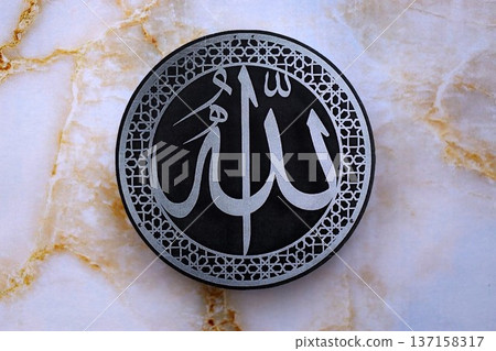 Sign with Islam inscription on table in mosque. Details of arabic calligraphy on paper sticker. Concept of Islam religion and praying in arabic countries Sign with Islam inscription on table in mosque. Details of arabic calligraphy on paper sticker. Concept of Islam religion and praying in arabic countries 137158317