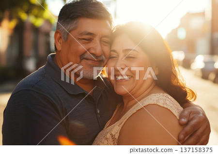 Happy Hispanic Senior Couple Embracing at Golden Hour 137158375