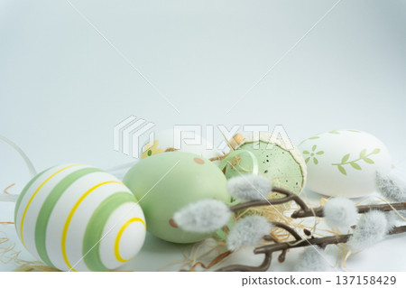 Colorful decorated eggs arranged with twigs and soft fibers on a plain surface during the Easter season Colorful decorated eggs arranged with twigs and soft fibers on a plain surface during the Easter season 137158429