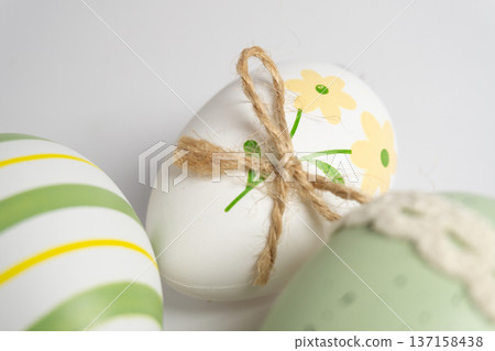 Decorative eggs with floral designs and twine tying on a white background during a spring celebration Decorative eggs with floral designs and twine tying on a white background during a spring celebration 137158438