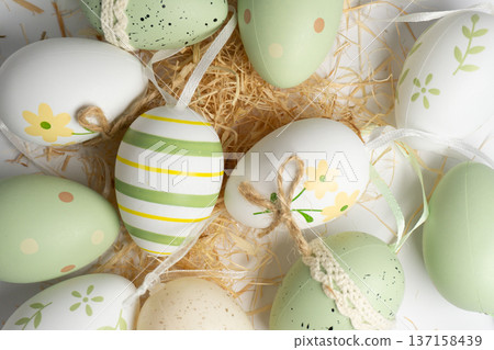 Colorful Easter eggs arranged on a bed of straw ready for an Easter celebration in springtime Colorful Easter eggs arranged on a bed of straw ready for an Easter celebration in springtime 137158439