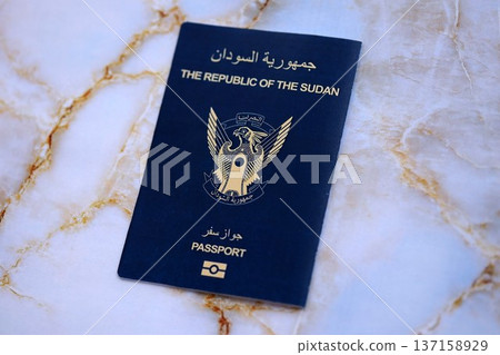 Sudanese passport on table close up. Official identification document book for citizens of Sudan. Concept of travel and tourism Sudanese passport on table close up. Official identification document book for citizens of Sudan. Concept of travel and tourism 137158929
