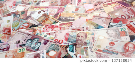 Various currencies money bills banknotes in red color. Many cash bills from different countries in big pile close up. World economy and currency exchange concept Various currencies money bills banknotes in red color. Many cash bills from different countries in big pile close up. World economy and currency exchange concept 137158934