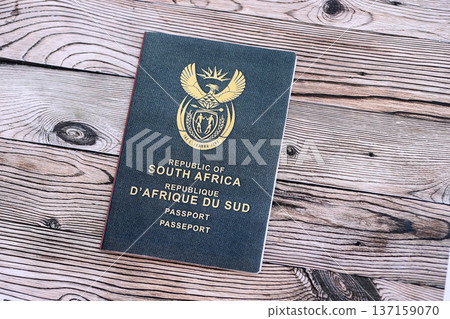 South African passport on table close up. Official identification document book for citizens of South Africa. Concept of travel and tourism South African passport on table close up. Official identification document book for citizens of South Africa. Concept of travel and tourism 137159070