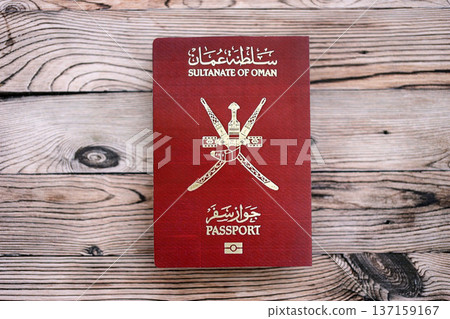 Omani passport on table close up. Official identification document book for citizens of Oman. Concept of travel and tourism Omani passport on table close up. Official identification document book for citizens of Oman. Concept of travel and tourism 137159167