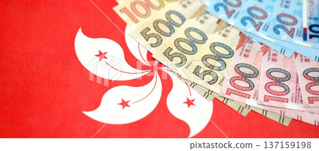 Big pile of Hong Kong dollars money bills banknotes on red flag. Lots of money of Chinese Hong Kong HKD currency cash. Economics and business in HongKong 137159198