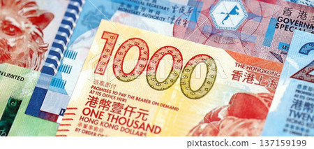 Big pile of Hong Kong dollars money bills banknotes close up. Lots of money of Chinese Hong Kong HKD currency cash in big bunch. Economics and business in HongKong Big pile of Hong Kong dollars money bills banknotes close up. Lots of money of Chinese Hong Kong HKD currency cash in big bunch. Economics and business in HongKong 137159199