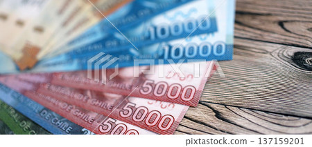 Big amount of chilean pesos money bills banknotes on wooden table. Huge quantity of paper money from Chile country close up. Concept of business and economy in Chile Big amount of chilean pesos money bills banknotes on wooden table. Huge quantity of paper money from Chile country close up. Concept of business and economy in Chile 137159201