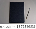 Notebook and pen placed on a plain surface ready for writing notes and ideas during day or night sessions 137159358