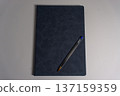 Notebook and pen placed on a light surface for writing notes and ideas during study or work time in a simple setting 137159359
