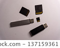 Different types of storage devices including USB drives and memory cards placed on a light background 137159361