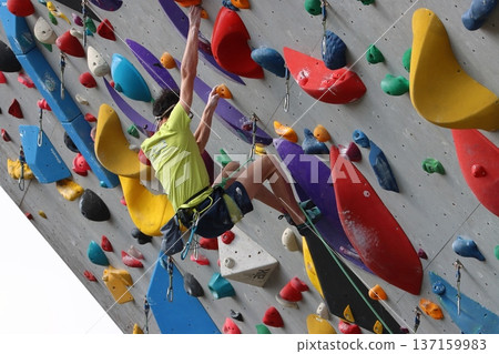 Athlete climbing a wall in bouldering Athlete climbing a wall in bouldering 137159983