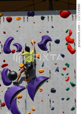 Athlete climbing a wall in bouldering Athlete climbing a wall in bouldering 137159986