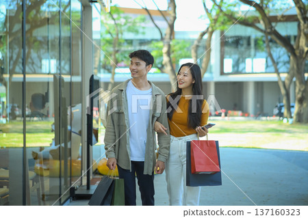 Happy young couple walking in the community mall Happy young couple walking in the community mall 137160323