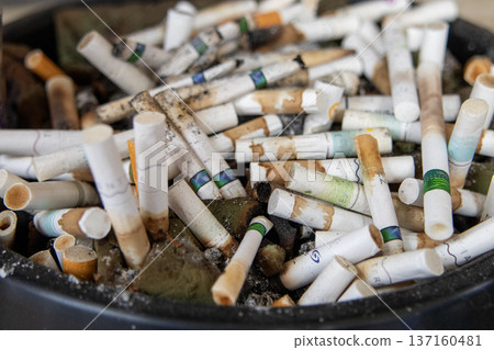 Close-up of an ashtray full of cigarette butts 137160481