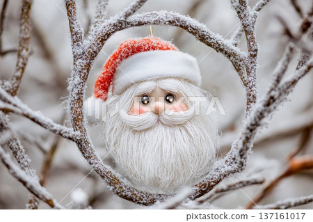 Santa Claus ornament with fluffy white beard nestled among twigs as festive decoration for holiday cheer Santa Claus ornament with fluffy white beard nestled among twigs as festive decoration for holiday cheer 137161017