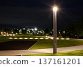 An empty park bench and an illuminated street lamp 137161201