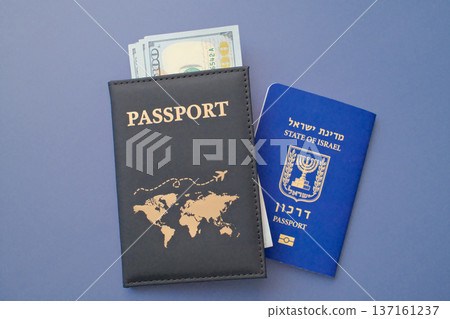 Israeli passport with US dollar banknotes in leather cover on gray background, travel and immigration finance concept Israeli passport with US dollar banknotes in leather cover on gray background, travel and immigration finance concept 137161237