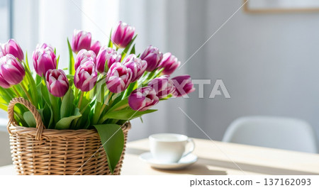 Bright spring still life of purple and white tulips in a wicker basket on a wooden table near a sunlit window with a coffee cup Bright spring still life of purple and white tulips in a wicker basket on a wooden table near a sunlit window with a coffee cup 137162093
