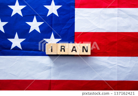 Iran wooden blocks on american flag showing conflict Iran wooden blocks on american flag showing conflict 137162421