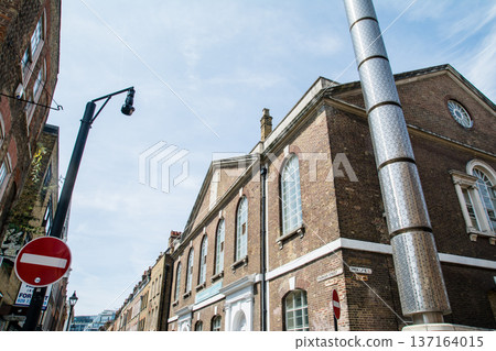 A street lined with historic brick buildings under bright sunlight in Shoreditch, East London A street lined with historic brick buildings under bright sunlight in Shoreditch, East London 137164015