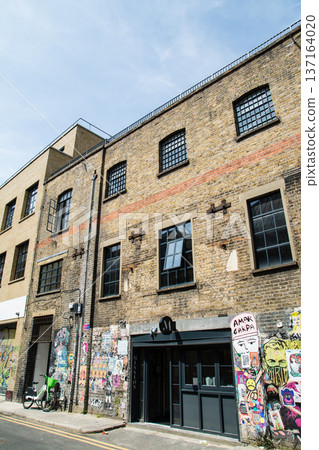 A street lined with historic brick buildings under bright sunlight in Shoreditch, East London A street lined with historic brick buildings under bright sunlight in Shoreditch, East London 137164020