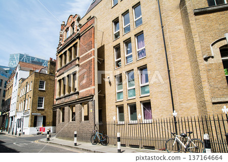 A street lined with historic brick buildings under bright sunlight in Shoreditch, East London 137164664