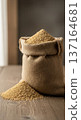 Animal feed granules in a burlap sack on wooden table for livestock nutrition 137164681