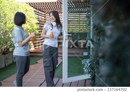 Morning Retreat: Two friends, a moment of friendship in the morning, holding drink on a bright day. Morning Retreat: Two friends, a moment of friendship in the morning, holding drink on a bright day. 137164792