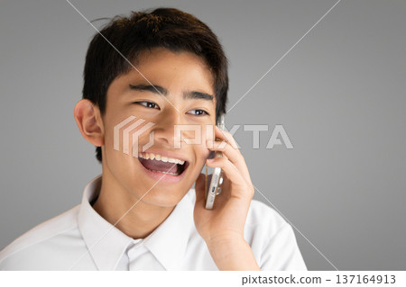 面帶微笑的學生正在用智慧型手機通話 137164913