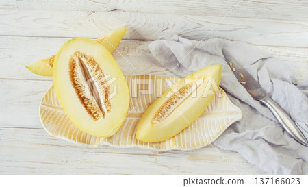 Slices ripe melon on white wooden background, close-up. Healthy eating, vegetarian food. Vitamin dessert. Slices ripe melon on white wooden background, close-up. Healthy eating, vegetarian food. Vitamin dessert. 137166023