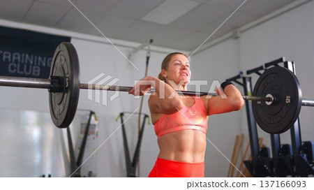Woman exercising with barbell in gym Woman exercising with barbell in gym 137166093