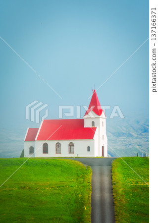 Holy Ingjaldsholskirkja church on green hill in misty landscape at Snaefellsnes peninsula, Iceland 137166371