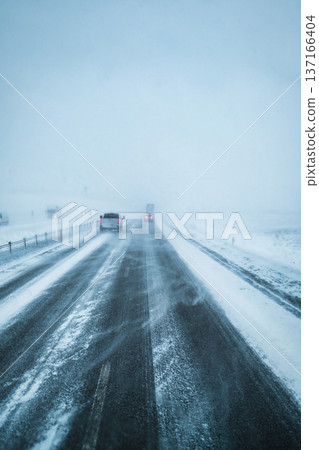 Car driving on snow covered road and blizzard windy Car driving on snow covered road and blizzard windy 137166404