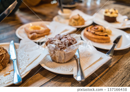 Fresh pastries and desserts served on plate with cutlery in cozy cafe Fresh pastries and desserts served on plate with cutlery in cozy cafe 137166438