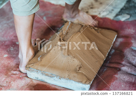 Traditional worker making and processing handmade clay tiles in rustic tile factory process 137166821